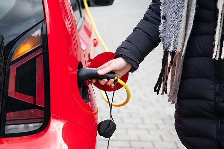 Mother and daughter charging their EV in front of School