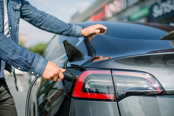 a person charging his ev with Xova Charger in front of a restaurant.