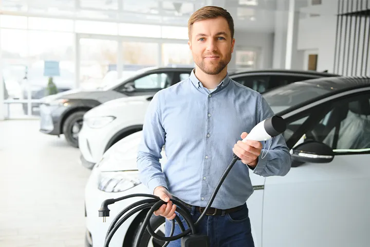 EV Consulting expert standing with Xova Charger in front of Electric Vehicle